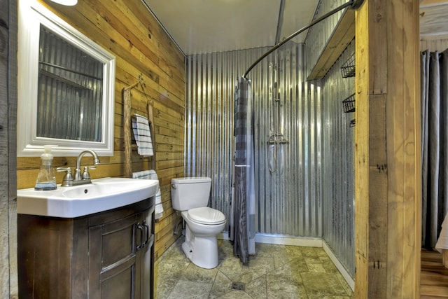 full bath with vanity, toilet, wood walls, stone finish flooring, and curtained shower