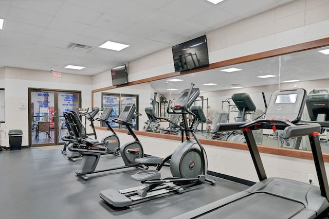 exercise room with visible vents and a paneled ceiling
