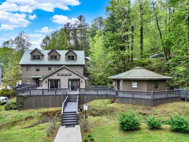view of front of house featuring metal roof, a wooden deck, and stairs