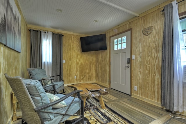 sitting room with baseboards, wood finished floors, and wooden walls