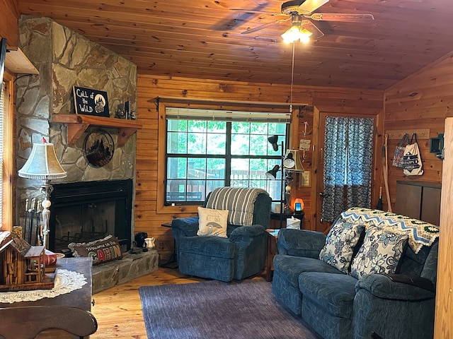 29 River Ranch Rd, Ellijay, GA 30540 - living room featuring vaulted ceiling, wooden walls, a ceiling fan, wood finished floors, and a stone fireplace