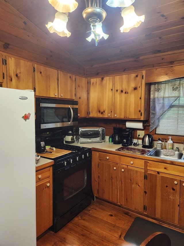 29 River Ranch Rd, Ellijay, GA 30540 - kitchen featuring freestanding refrigerator, black gas range, stainless steel microwave, dark wood-style flooring, and light countertops