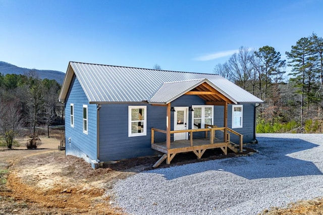 view of front of property with metal roof and a deck with mountain view