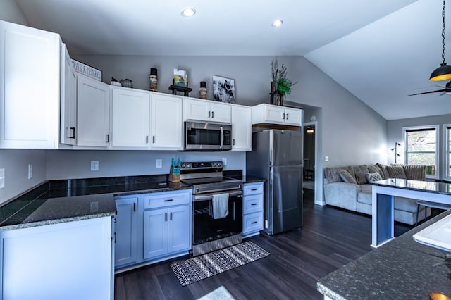 kitchen featuring dark wood-style floors, appliances with stainless steel finishes, open floor plan, white cabinets, and vaulted ceiling