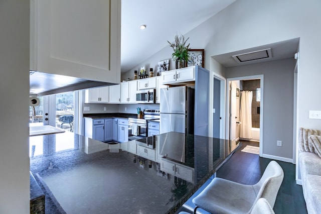 kitchen featuring high vaulted ceiling, white cabinetry, baseboards, appliances with stainless steel finishes, and dark wood-style floors