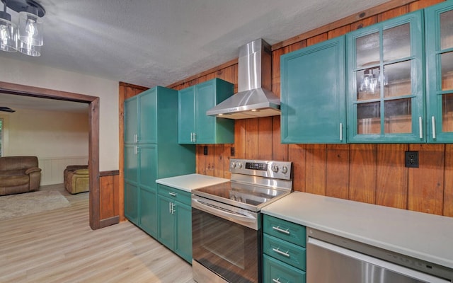 469 Hidden Valley Dr, Morganton, GA 30560 - kitchen featuring appliances with stainless steel finishes, wall chimney range hood, light countertops, light wood-type flooring, and a wainscoted wall