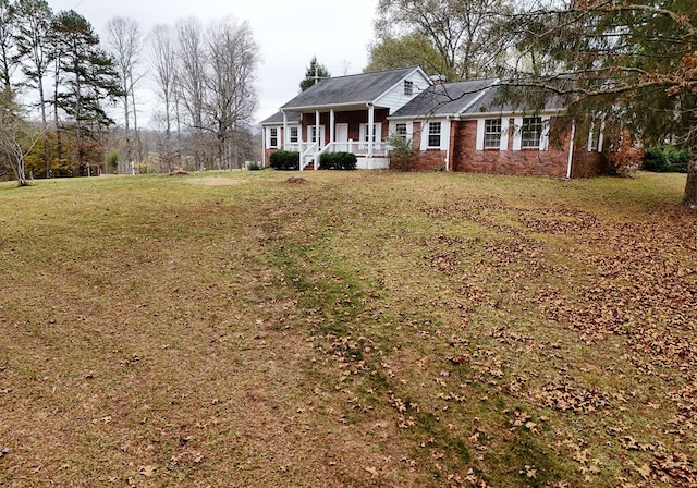 ranch-style home featuring a front yard and covered porch