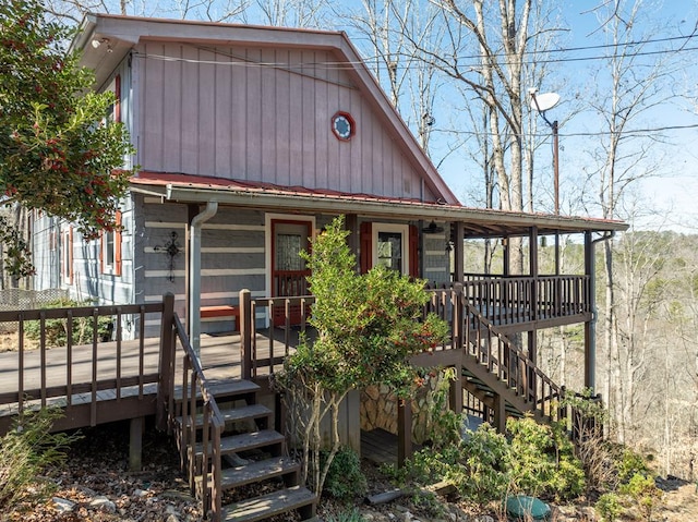 view of front facade featuring stairs, metal roof, and covered porch