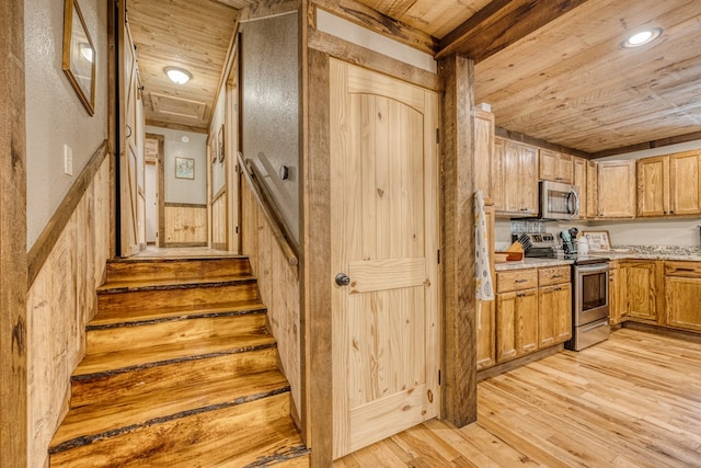 kitchen featuring light countertops, wood ceiling, light wood finished floors, and stainless steel appliances