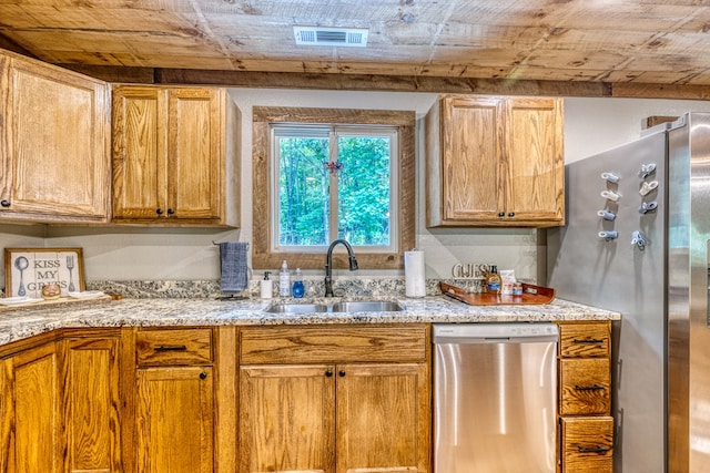 kitchen with a sink, visible vents, light stone counters, and appliances with stainless steel finishes