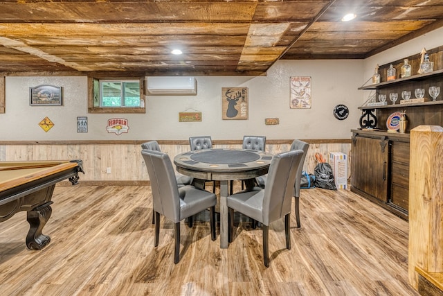 dining room featuring wooden walls, light wood finished floors, a wall mounted air conditioner, and wainscoting