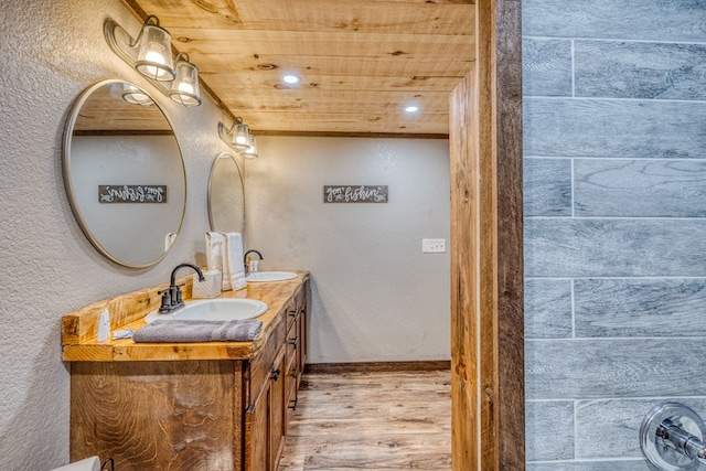 bathroom with wood finished floors, wood ceiling, double vanity, and a sink