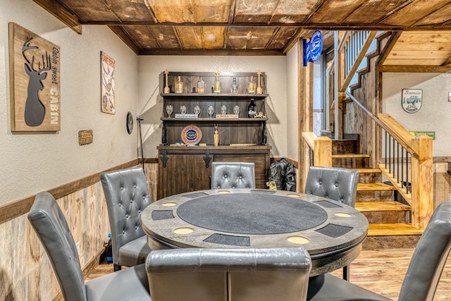 dining area featuring wood ceiling, wood finished floors, stairs, and a textured wall