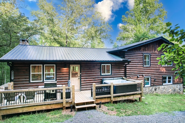 rear view of house featuring metal roof and a chimney