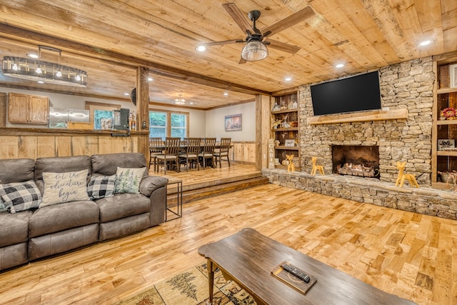 living area featuring a ceiling fan, wood ceiling, wood finished floors, and a fireplace