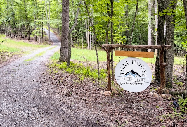 community / neighborhood sign with a forest view