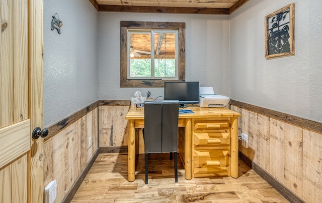 office with wooden walls, light wood-type flooring, and wainscoting