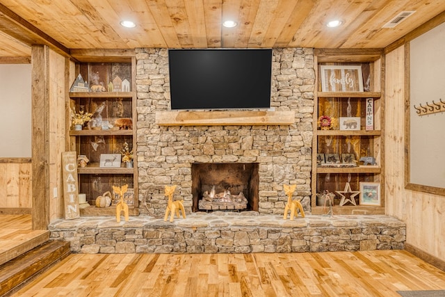 unfurnished living room with built in features, wainscoting, wood ceiling, and wood finished floors