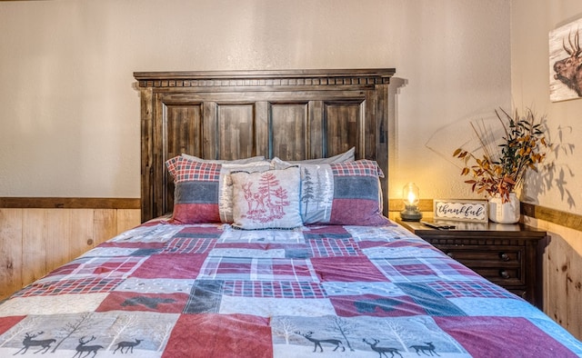 bedroom with wood walls and wainscoting