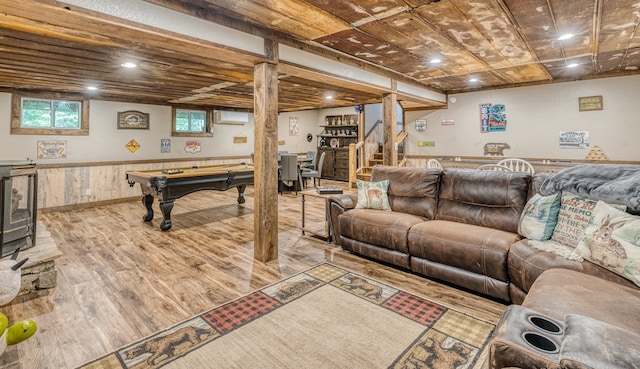 living room featuring a wealth of natural light, a wall mounted air conditioner, stairs, and wood finished floors