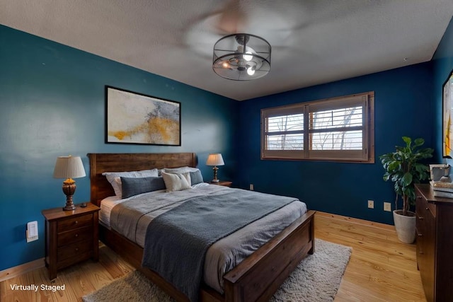 bedroom with baseboards and wood finished floors