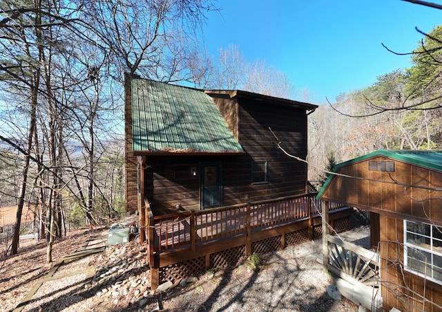 exterior space with a wooden deck and metal roof