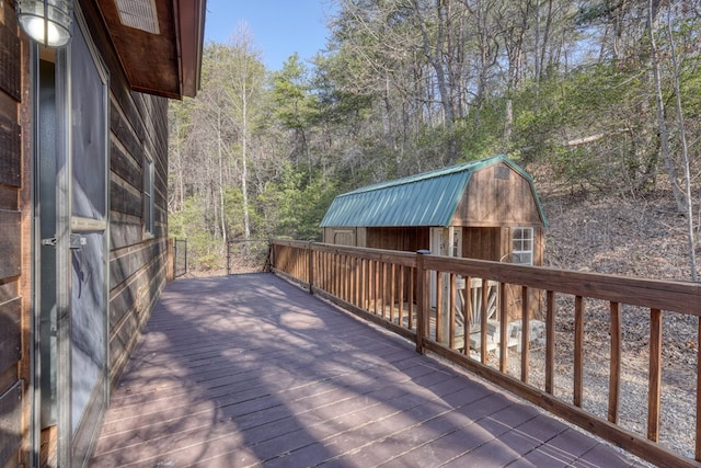 wooden terrace featuring an outbuilding and a storage shed