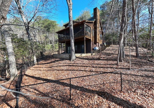 rear view of house featuring a wooden deck and a chimney