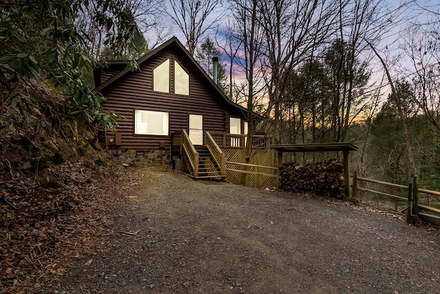 back house at dusk featuring a wooden deck