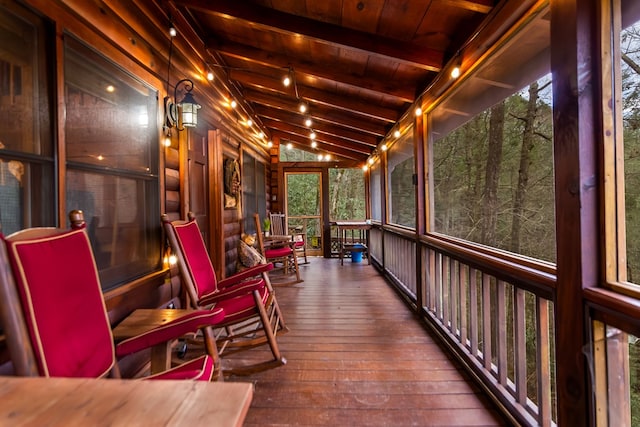 sunroom / solarium featuring vaulted ceiling with beams and wood ceiling