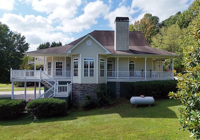 view of front of home featuring a shingled roof, stairway, a front yard, covered porch, and a chimney