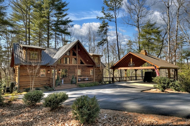 view of front of house with a carport, metal roof, and driveway