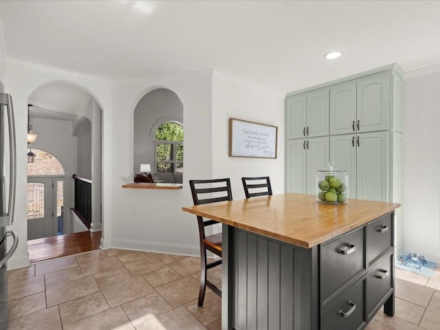 dining room with light tile patterned floors and ornamental molding