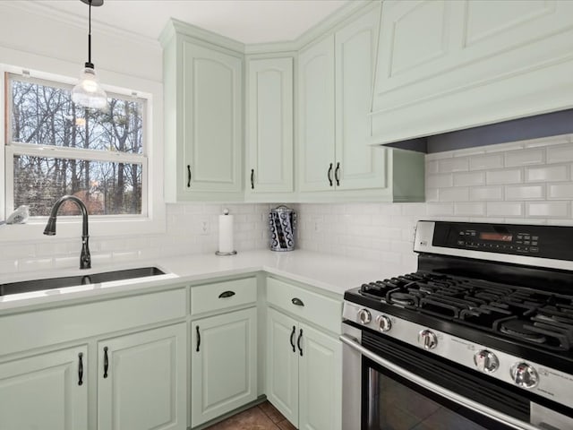 kitchen with tasteful backsplash, sink, custom range hood, and stainless steel gas stove