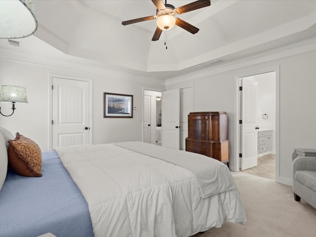 bedroom featuring ensuite bathroom, light colored carpet, ornamental molding, a raised ceiling, and ceiling fan