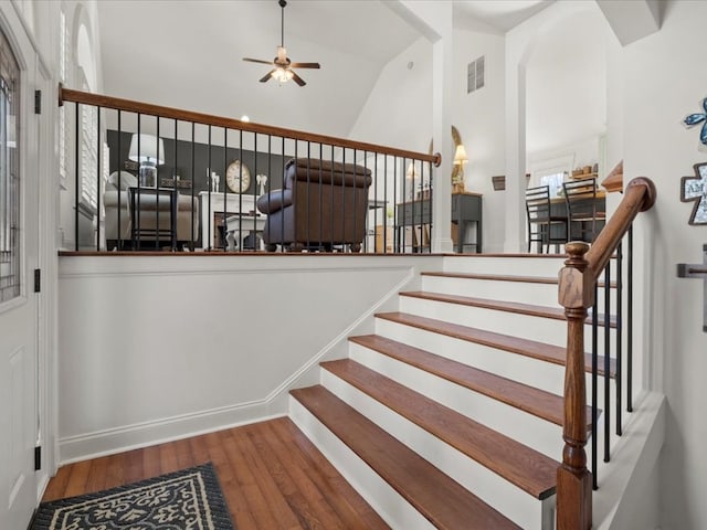 stairway with lofted ceiling, hardwood / wood-style flooring, and ceiling fan