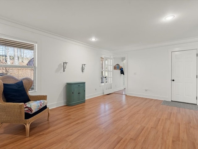 sitting room featuring a wealth of natural light, ornamental molding, and light hardwood / wood-style floors