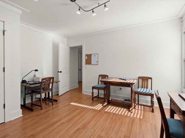 interior space with crown molding, track lighting, and light hardwood / wood-style floors