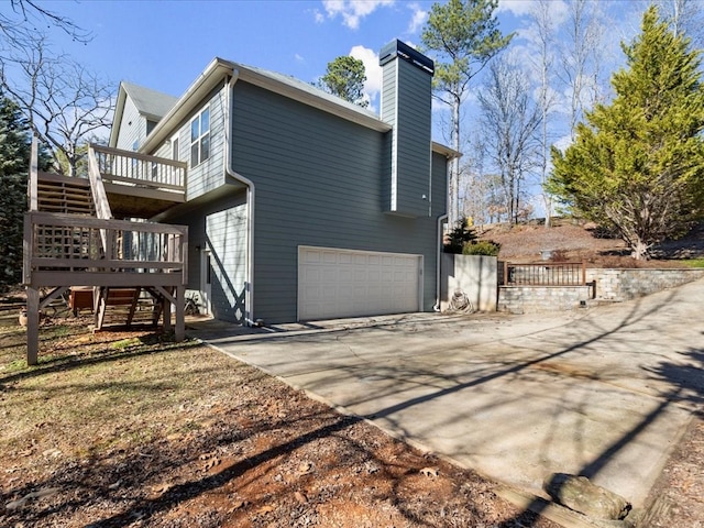 view of side of property featuring a garage and a deck