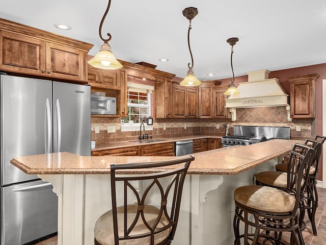 kitchen with sink, a center island, hanging light fixtures, stainless steel appliances, and premium range hood