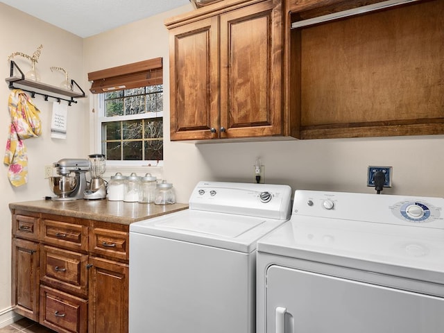 clothes washing area featuring cabinets and washing machine and dryer