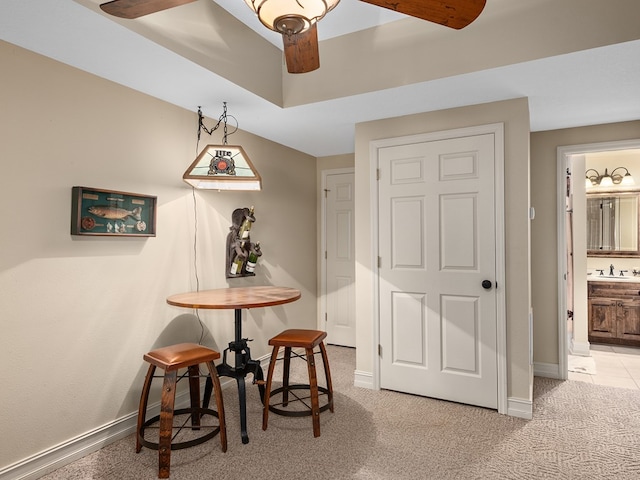 dining room with light colored carpet, ceiling fan, and sink