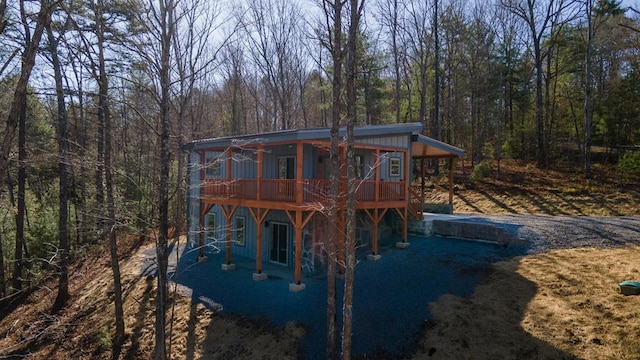 exterior space with a deck and a view of trees