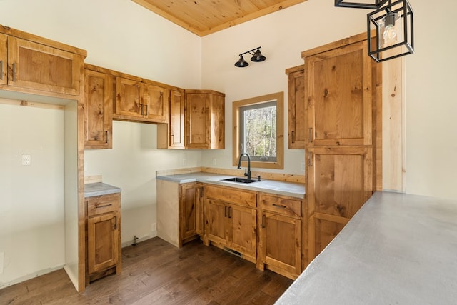 kitchen with dark wood-style floors, brown cabinets, light countertops, a sink, and wooden ceiling