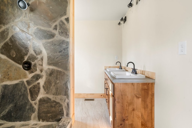 full bath featuring visible vents, a shower, and vanity