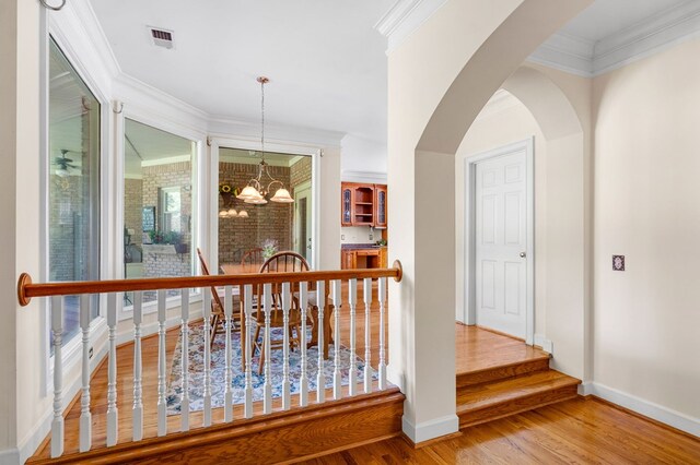 226 Euharlee Five Forks Rd, Kingston, GA 30145 - hall featuring wood finished floors, a chandelier, baseboards, crown molding, and arched walkways