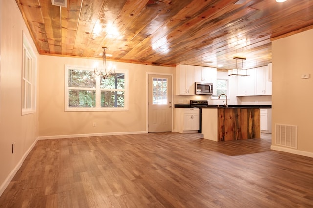 61 Morningside Ct, Ellijay, GA 30540 - kitchen with a chandelier, stainless steel microwave, wooden ceiling, dark countertops, and light wood-style flooring