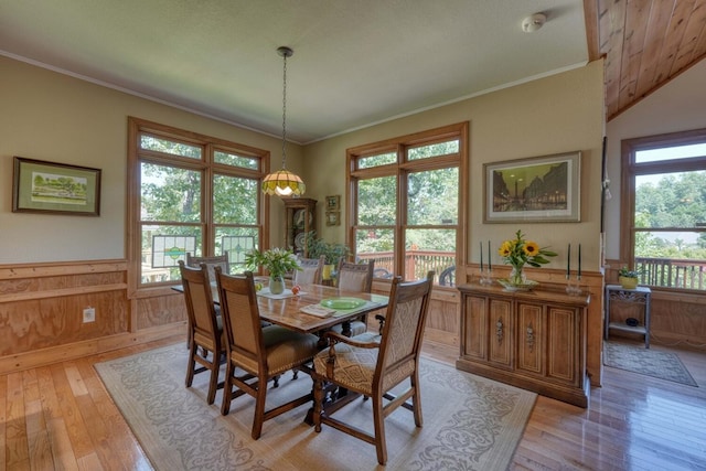 dining area featuring vaulted ceiling, light hardwood / wood-style floors, and crown molding