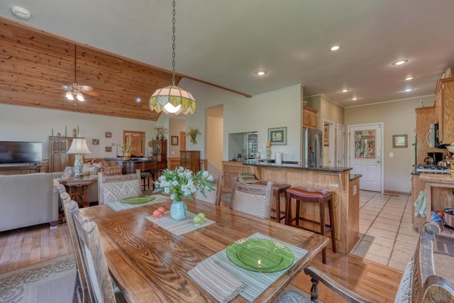 dining area featuring ceiling fan, light hardwood / wood-style floors, lofted ceiling, and ornamental molding