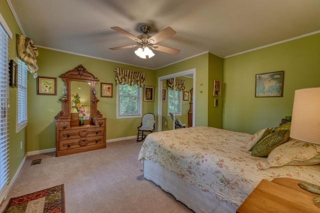 carpeted bedroom with ceiling fan, ornamental molding, and a closet